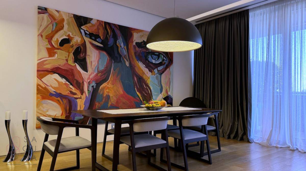Eleganter Essbereich mit Holztisch, modernen Stühlen und einem farbenfrohen Kunstwerk an der Wand.