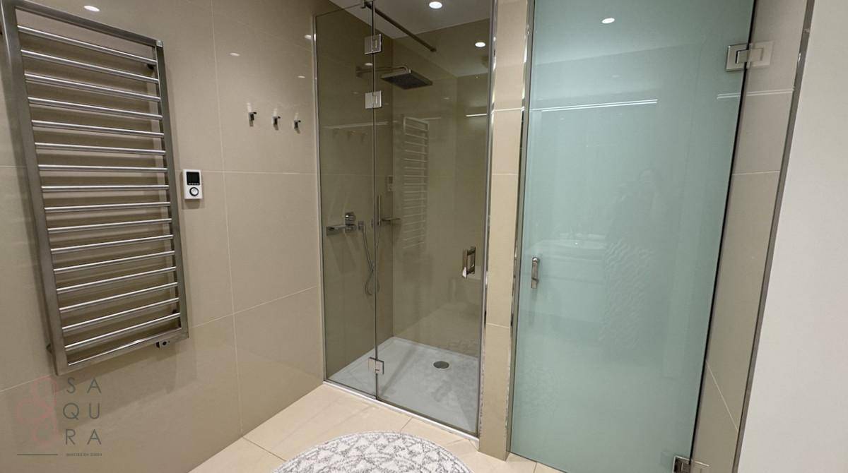 Zeitgemäßes Badezimmer mit geräumiger begehbarer Dusche und beheiztem Handtuchhalter.