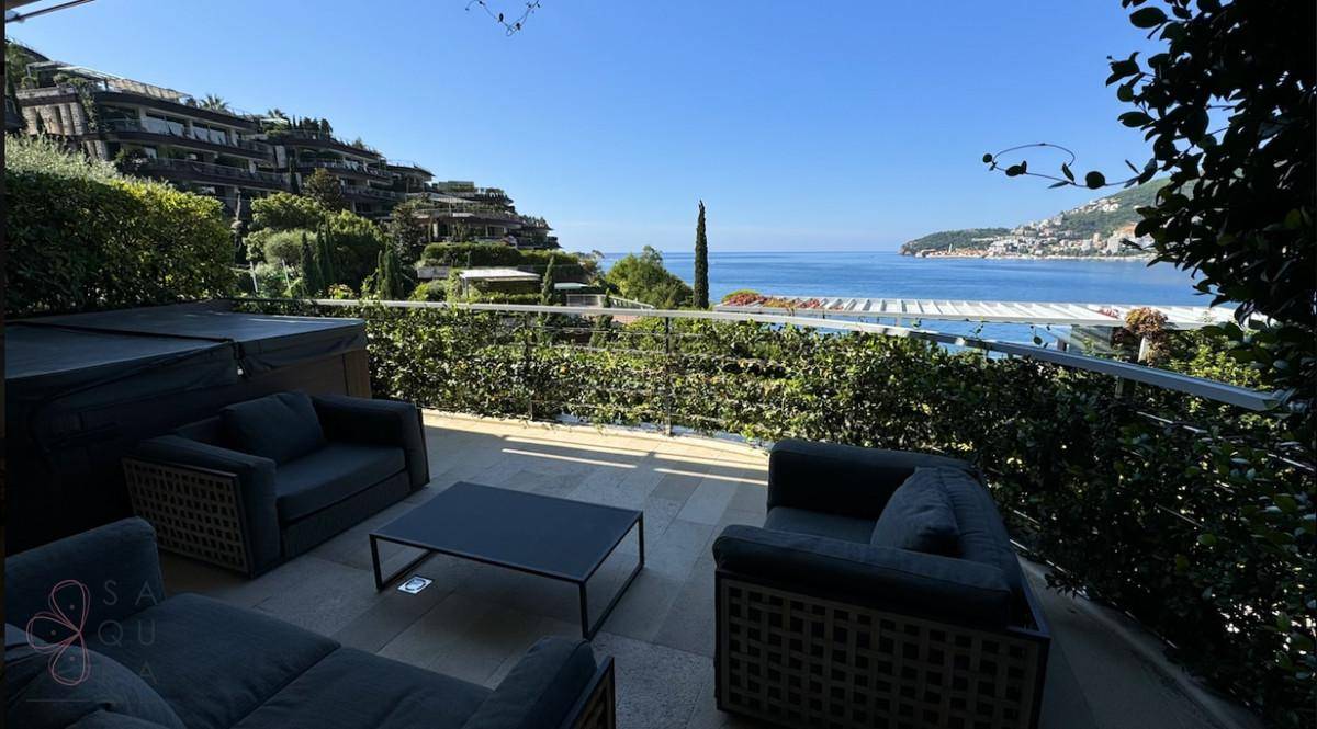 Sonnenterrasse mit bequemen Outdoor-Möbeln und Whirlpool, mit weitem Blick auf das Meer.