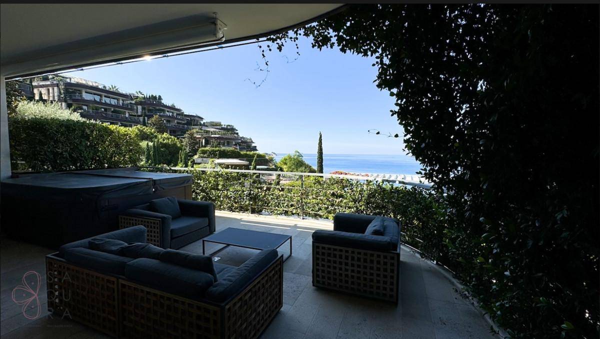 Schattige Terrasse mit Sitzgruppe und Whirlpool, bietet einen weiten Blick auf das Meer.