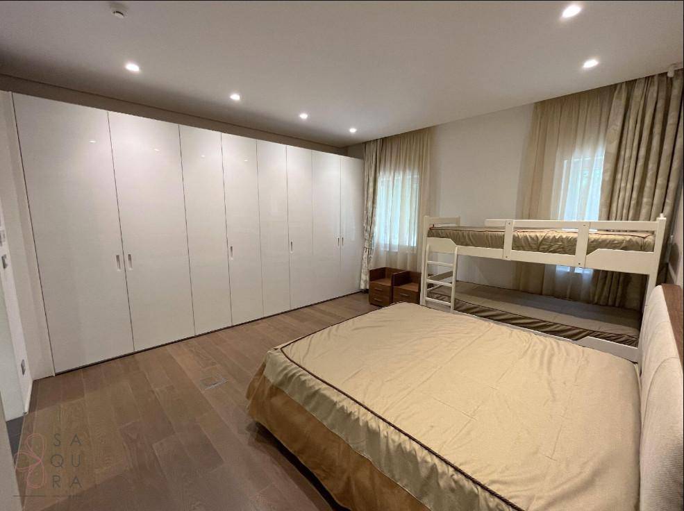 Geräumiges Schlafzimmer mit Doppelbett, Etagenbett und großen weißen Einbauschränken für viel Stauraum.
