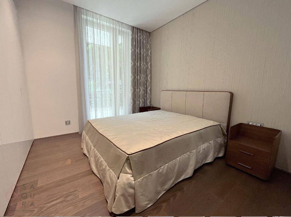 Gemütliches Schlafzimmer mit Doppelbett, Nachttisch und Fenster mit Vorhängen, das viel Tageslicht hereinlässt.