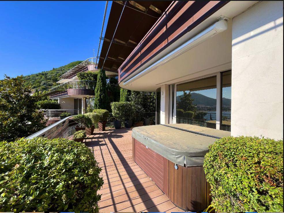 Große Terrasse mit Whirlpool und Blick auf die umliegende grüne Landschaft und die Architektur des Gebäudes.