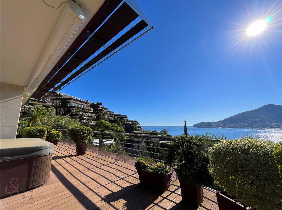 Sonnenterrasse mit Holzdeck, Pflanzen und Whirlpool, bietet einen atemberaubenden Blick auf das Meer und die Berge.