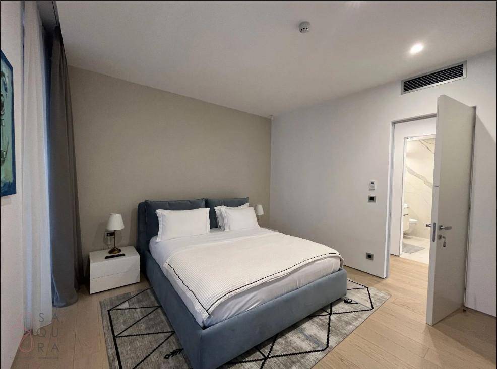 Schlafzimmer mit modernem Bett und offenem Zugang zu einem eleganten Badezimmer.