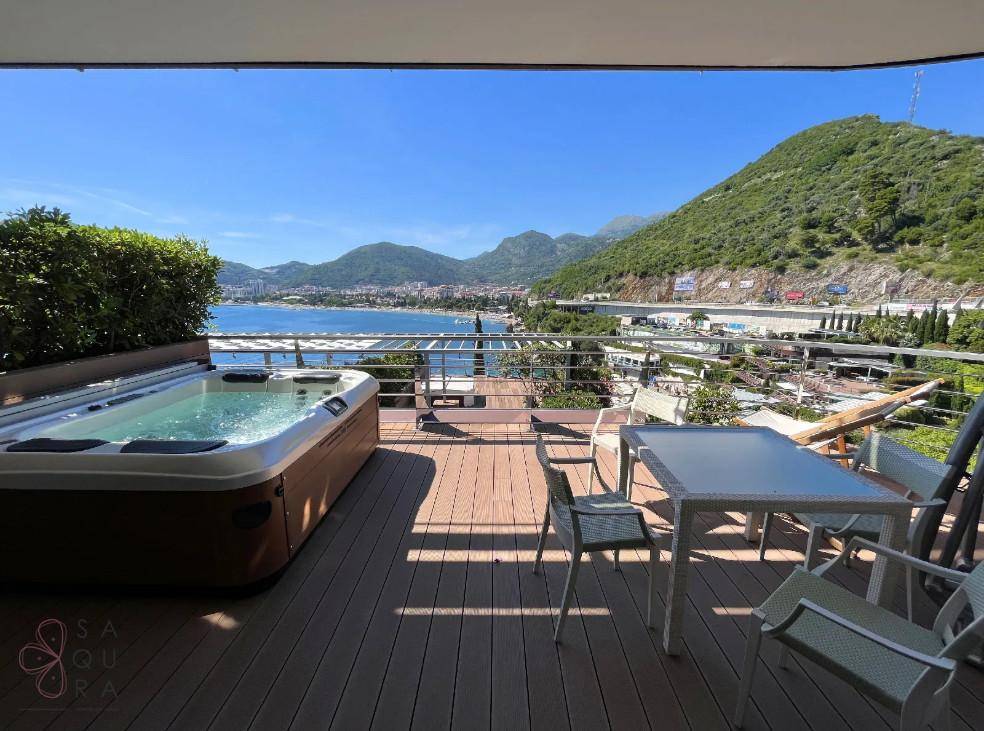 Große Terrasse mit Whirlpool, Sitzgelegenheiten und atemberaubendem Blick auf das Meer und die Berge.