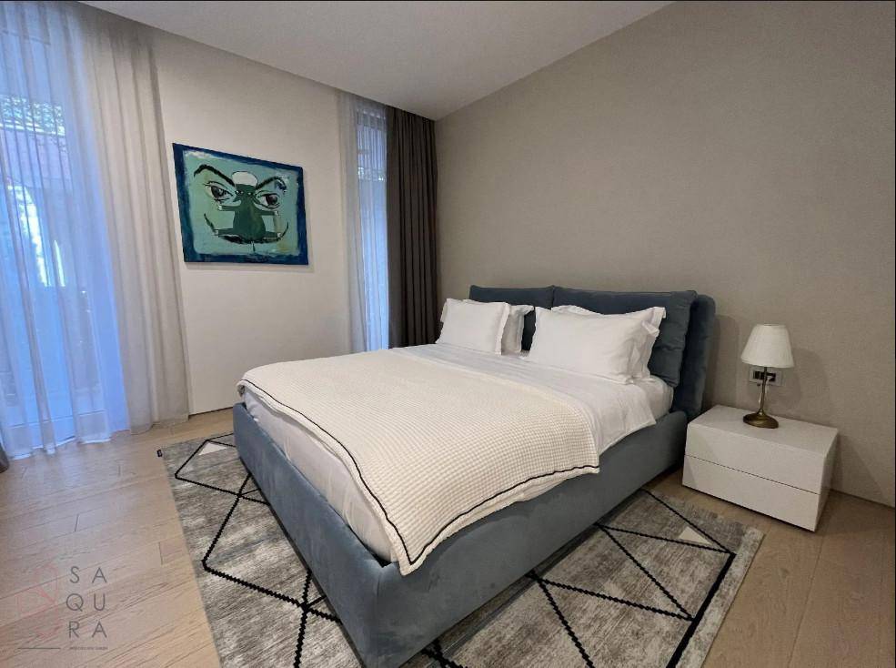 Gemütliches Schlafzimmer mit großem Bett, Nachttisch und Fenster für viel Tageslicht.