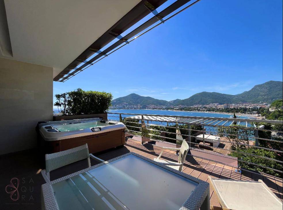 Exklusive Terrasse mit Whirlpool, Lounge-Möbeln und spektakulärem Blick auf das Meer und die Berge.
