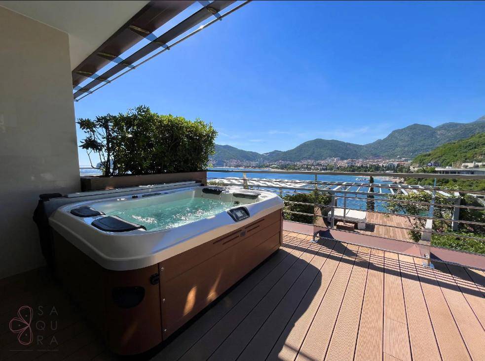 Sonnenterrasse mit luxuriösem Whirlpool und Panoramablick auf die Küste und die umliegenden Berge.