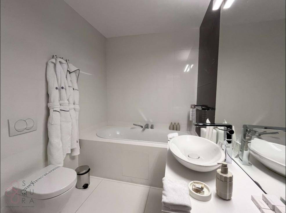 Modernes Badezimmer mit Badewanne, Toilette und stilvollem Aufsatzwaschbecken.