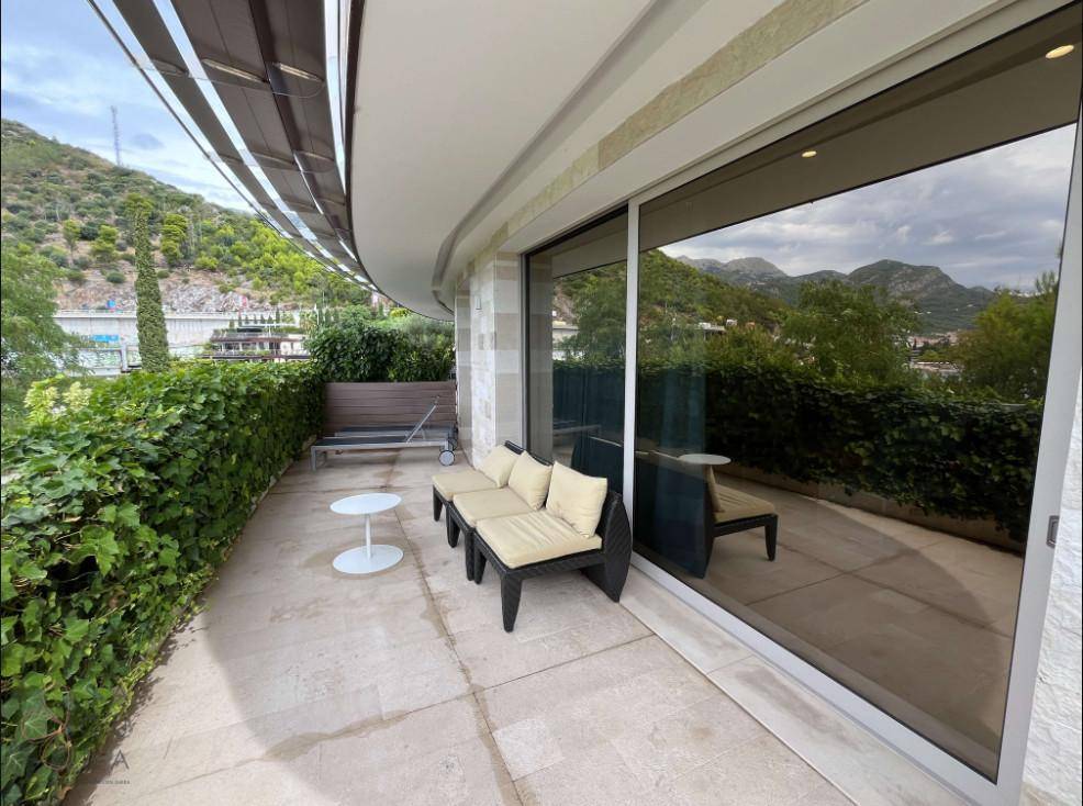 Geräumige Terrasse mit bequemen Loungemöbeln und Blick auf die umliegende Berglandschaft.