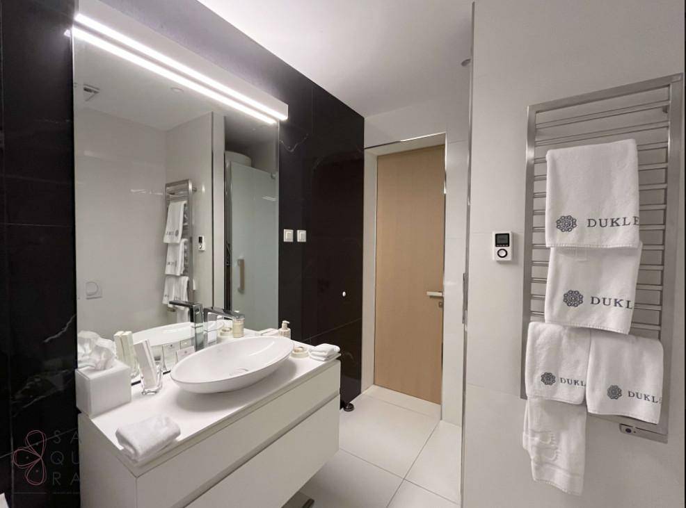 Elegantes Badezimmer mit großem Spiegel, Aufsatzwaschbecken und beheiztem Handtuchhalter.