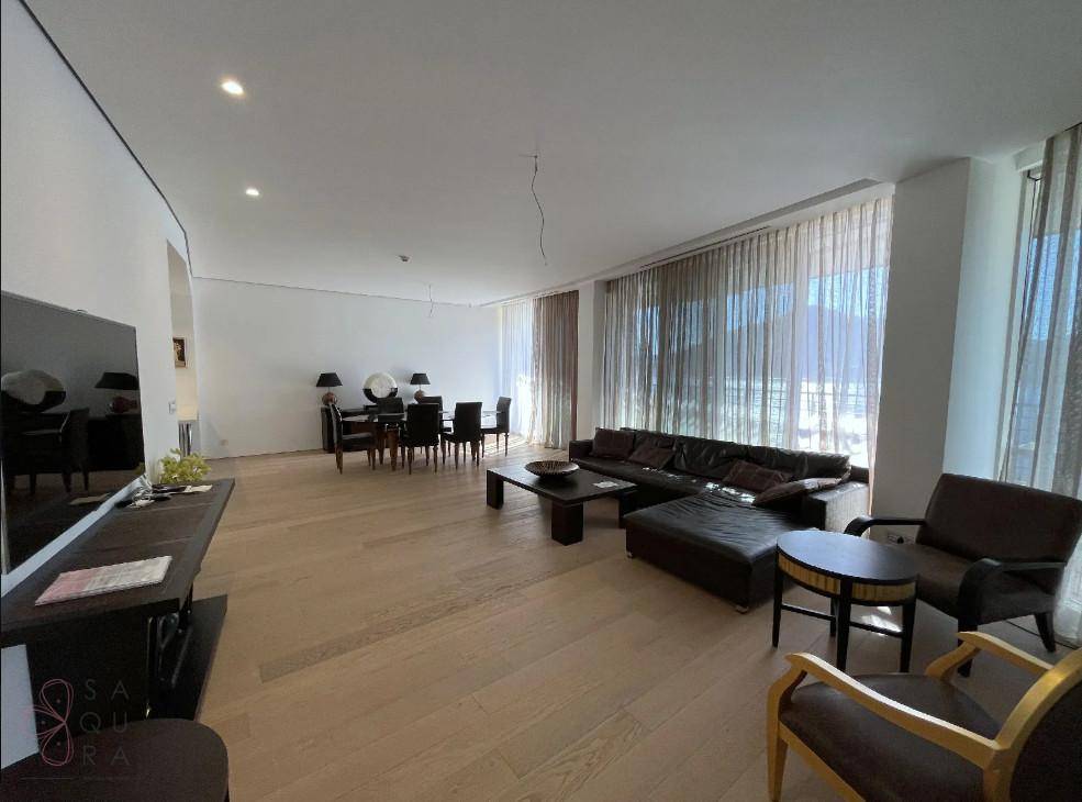 Heller Wohn- und Essbereich mit Holzboden, bequemer Couch und elegantem Esstisch.