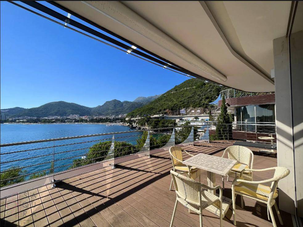 Große Terrasse mit Holzboden, Sitzgelegenheiten und atemberaubendem Meer- und Bergblick.