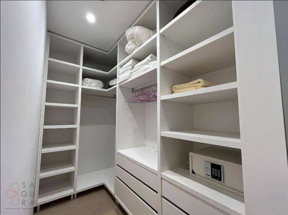 Gut organisiertes Ankleidezimmer mit vielen Regalen, Schubladen und einem Safe.