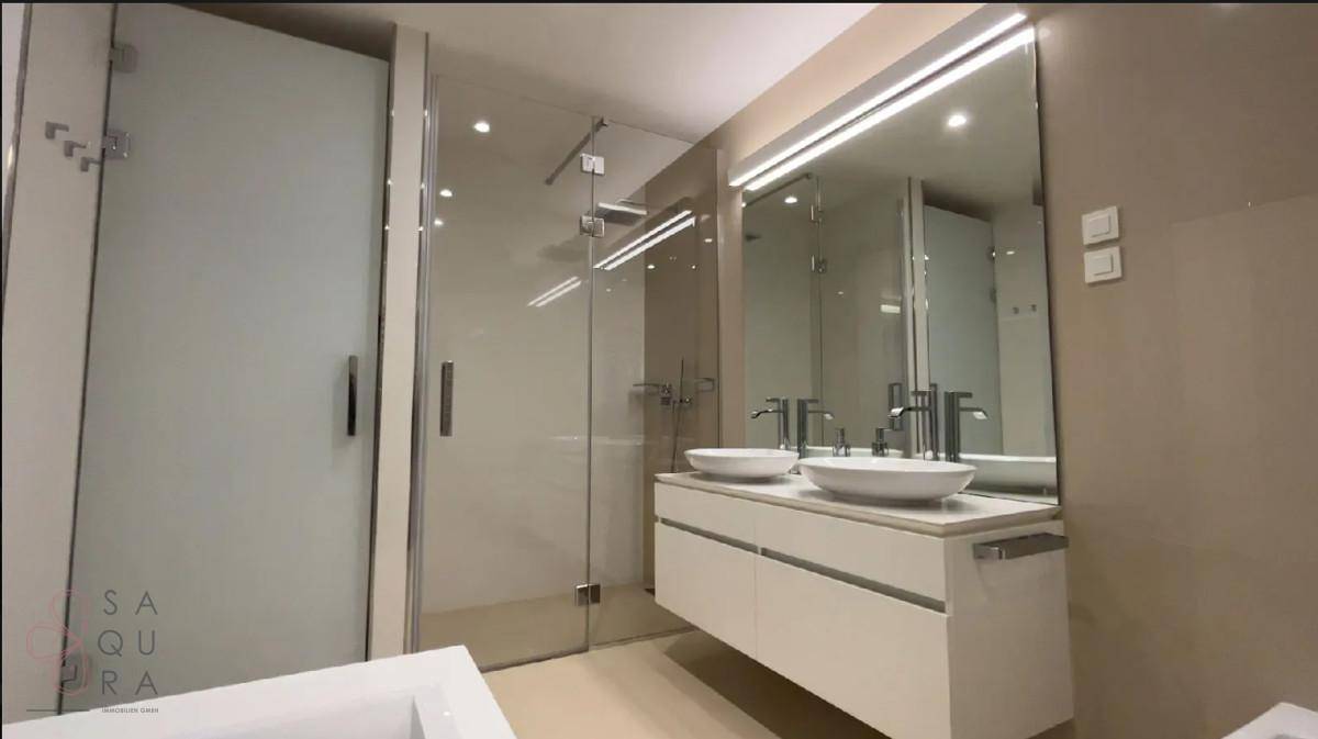 Geräumiges Badezimmer mit Doppelwaschbecken, Badewanne und begehbarer Dusche.