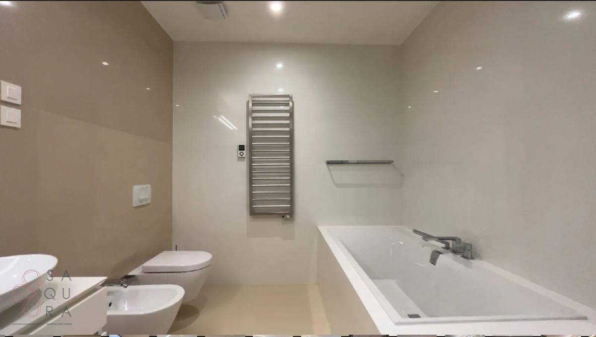 Elegantes Badezimmer mit Badewanne, Bidet, Toilette und beheiztem Handtuchhalter.