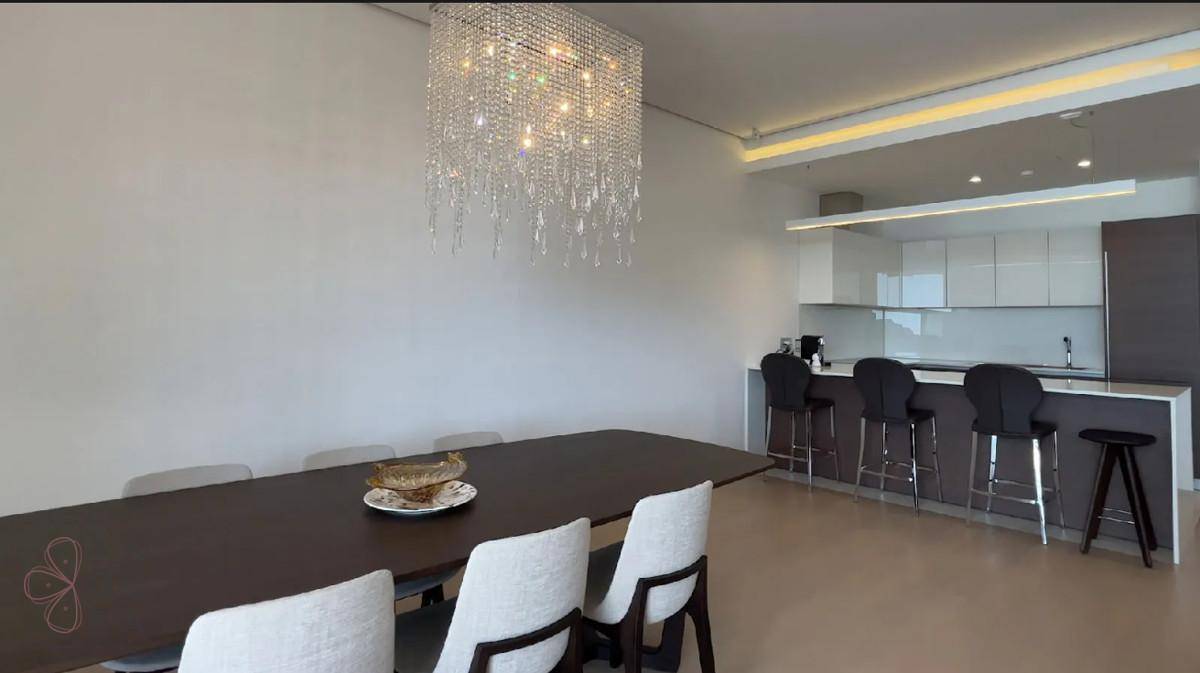 Eleganter Essbereich mit großem Tisch und offener, moderner Küche mit Barhockern.