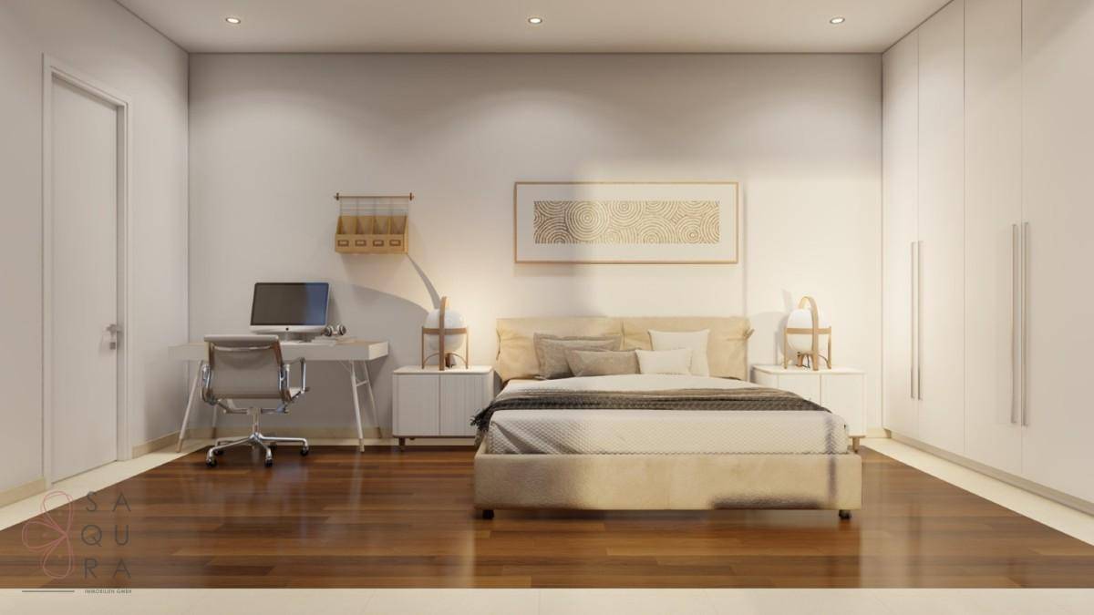 Helles Schlafzimmer mit Holzboden, Schreibtisch und integrierten Kleiderschränken.