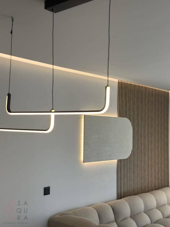Moderne Wandgestaltung mit Holzlamellen und indirekter Beleuchtung im Wohnbereich.