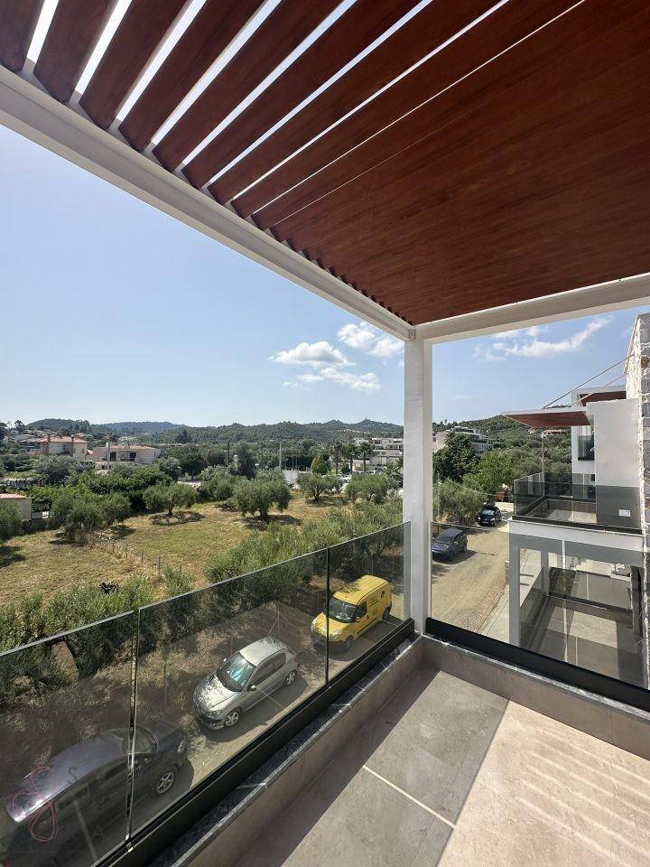 Geräumiger Balkon mit Glasbrüstung und weitem Blick über die Landschaft.