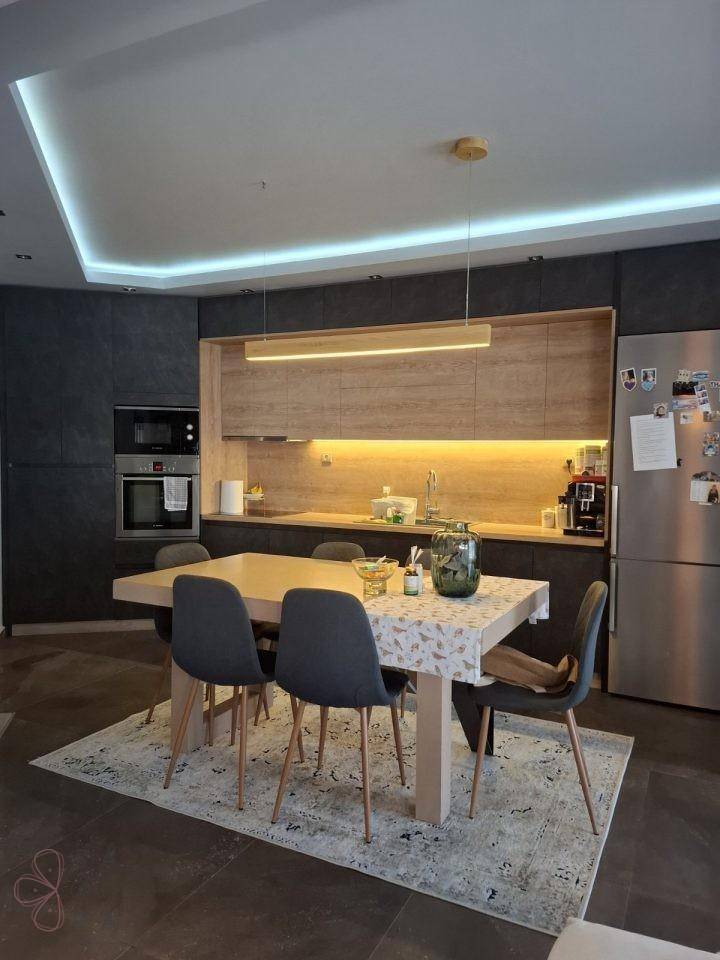 Geräumige Küche mit Essbereich, modernen Holzschränken und integriertem Kühlschrank.