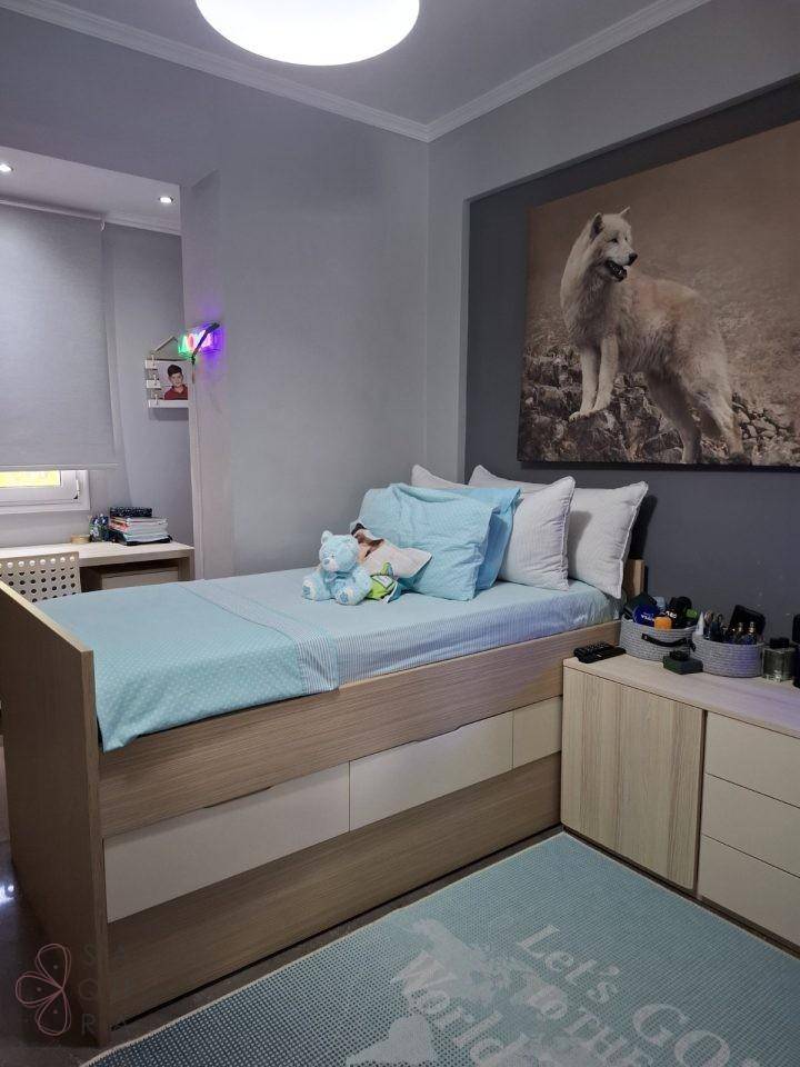 Helles Kinderzimmer mit Einzelbett, Schreibtisch und dekorativem Wandbild.