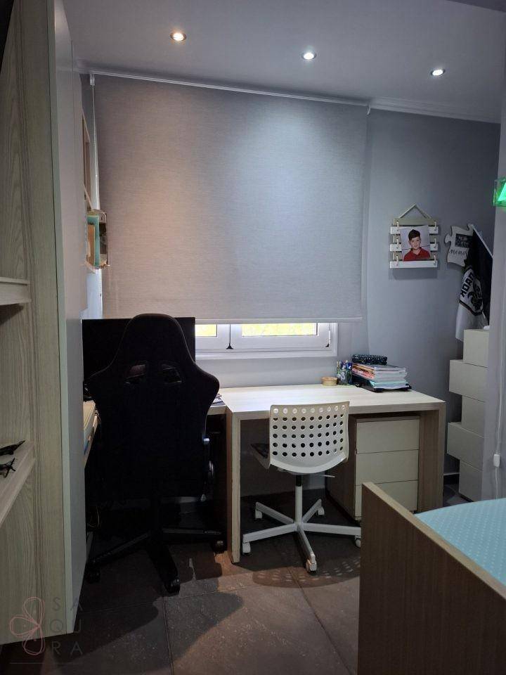 Arbeitsbereich im Kinderzimmer mit Schreibtisch, Bürostuhl und Fenster für Tageslicht.