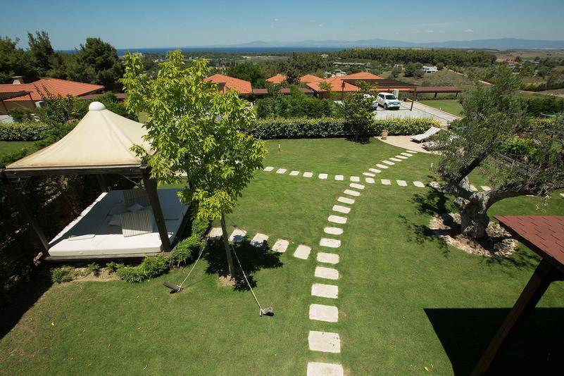 Überdachte Terrasse mit Essbereich und Lounge-Möbeln, ideal für Mahlzeiten im Freien.