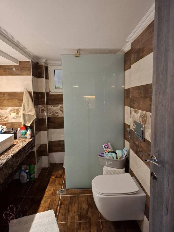 Modernes Badezimmer mit begehbarer Dusche, wandhängendem WC und stilvollen Fliesen.
