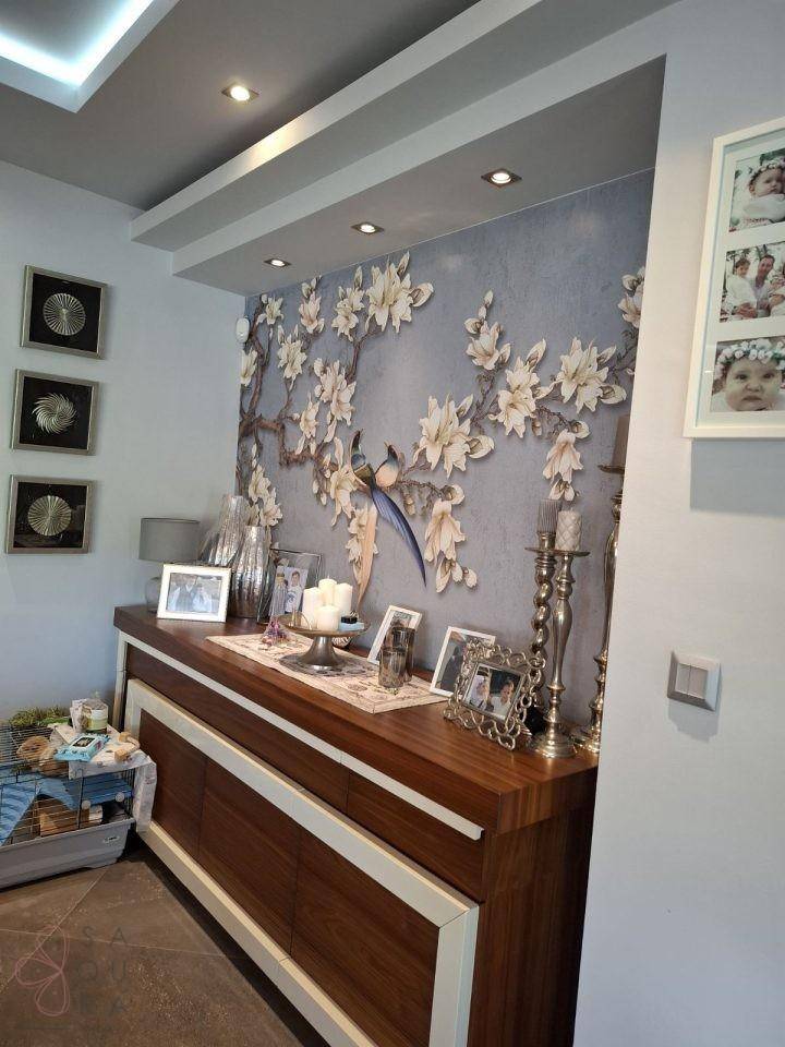 Flur oder Essbereich mit elegantem Sideboard und dekorativer floraler Wandtapete.
