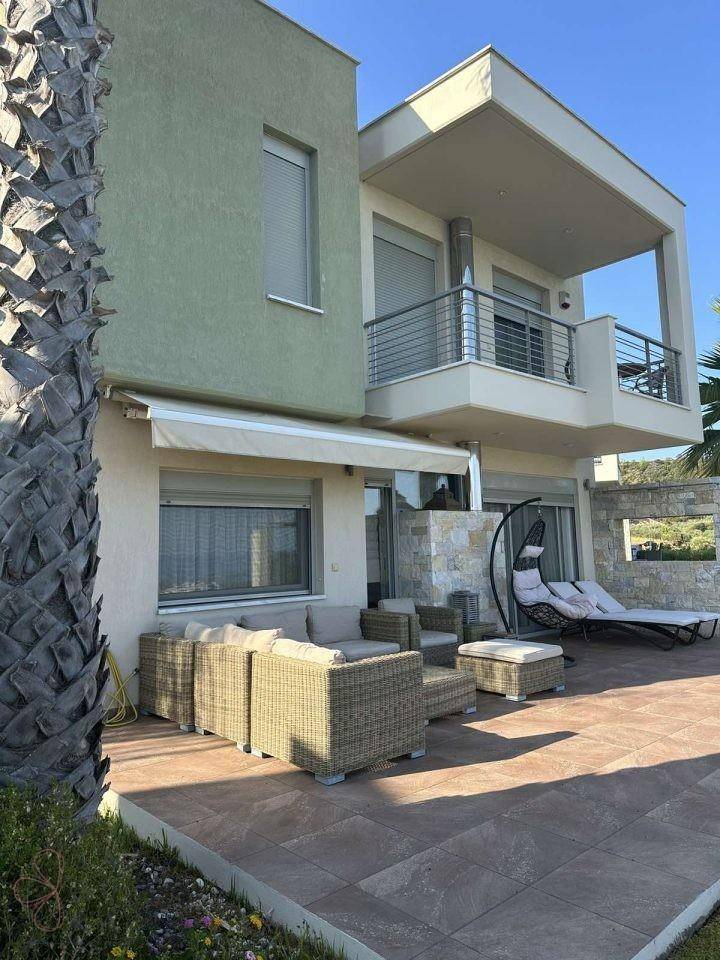 Geräumige Terrasse mit Lounge-Möbeln und Sonnenliegen vor der modernen Villa.