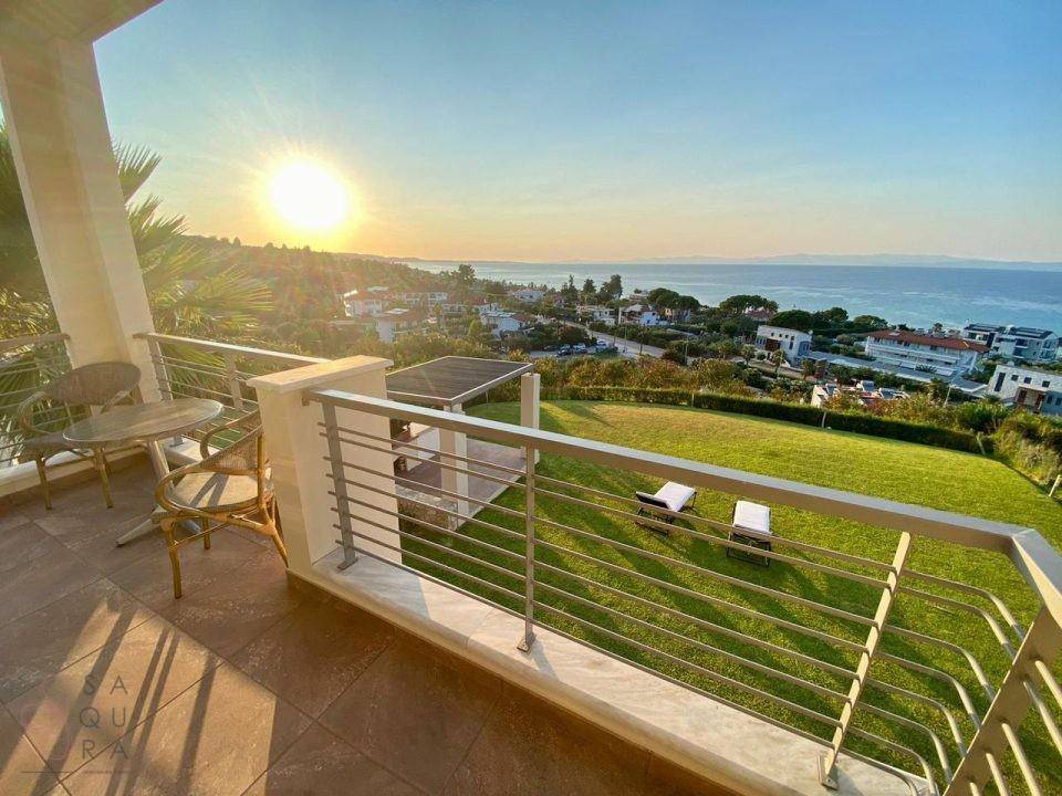 Geräumiger Balkon mit Sitzgelegenheiten und einem atemberaubenden Blick auf das Meer und den Garten.
