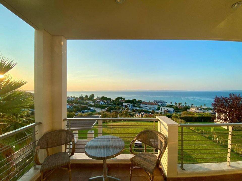 Möblierter Balkon mit Tisch und Stühlen, bietet einen herrlichen Blick auf das Meer.