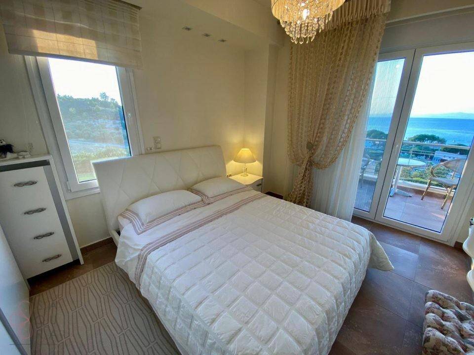 Helles Schlafzimmer mit Doppelbett, Balkonzugang und weitem Meerblick.