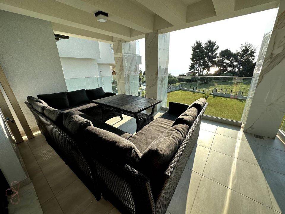 Überdachter Balkon mit Meerblick und bequemen Lounge-Möbeln, ideal für entspannte Stunden.