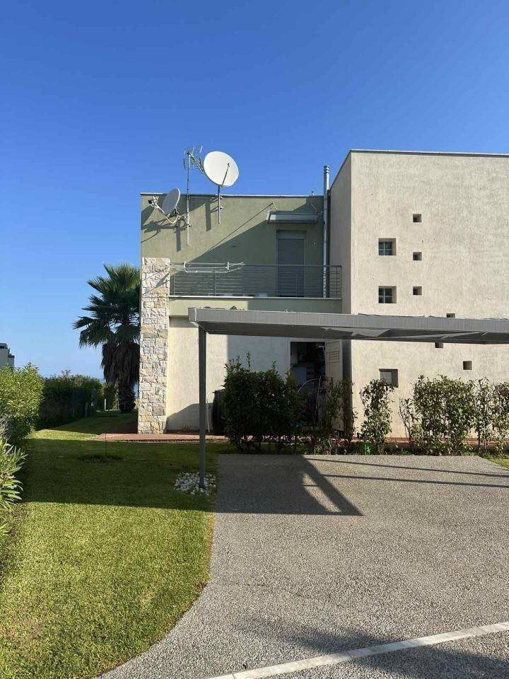 Moderne Villa mit Carport und gepflegtem Vorgarten, die eine klare Linienführung aufweist.