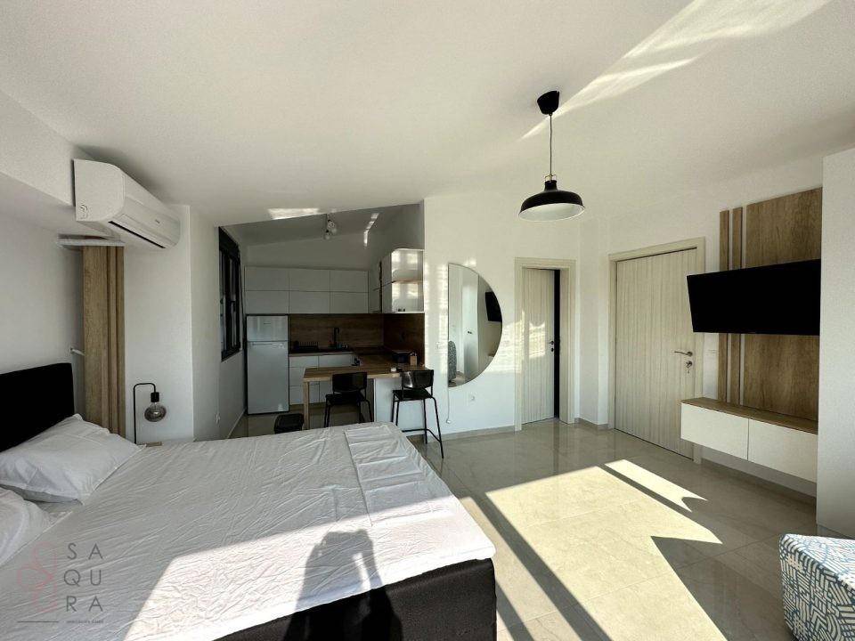 Offenes Studio-Schlafzimmer mit integrierter Küchenzeile, Doppelbett und modernem Design.