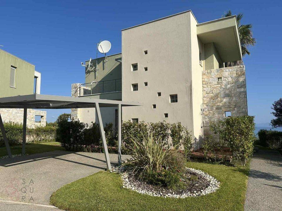 Moderne Villa mit Carport und gepflegtem Vorgarten, die eine zeitgemäße Architektur zeigt.