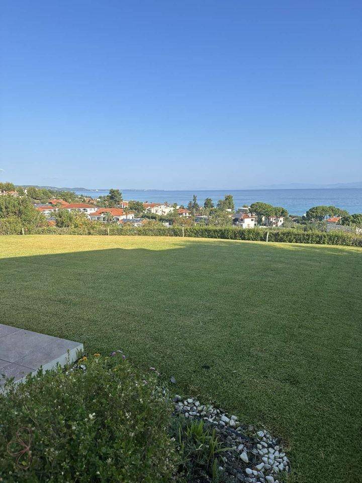 Weitläufiger, gepflegter Rasenbereich mit Blick auf das Meer und die umliegende Landschaft.
