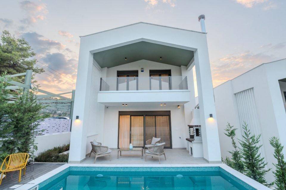 Moderne Villa mit klaren Linien, Balkon und privatem Poolbereich im Freien.