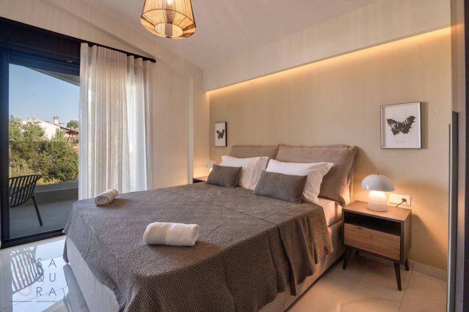 Helles Schlafzimmer mit Doppelbett, indirekter Beleuchtung und direktem Balkonzugang.