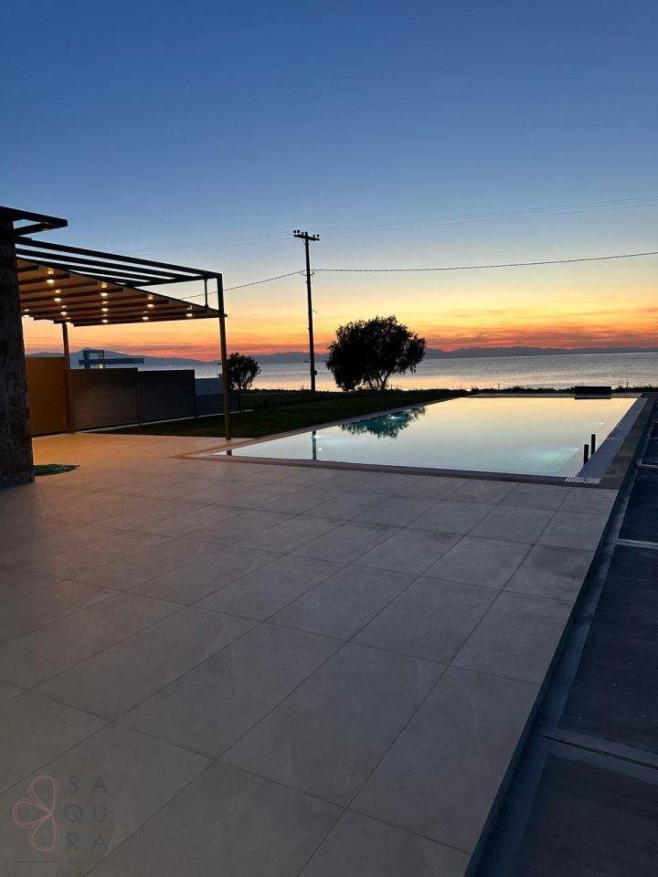 Infinity-Pool mit atemberaubendem Meerblick und farbenprächtigem Sonnenuntergang am Horizont.