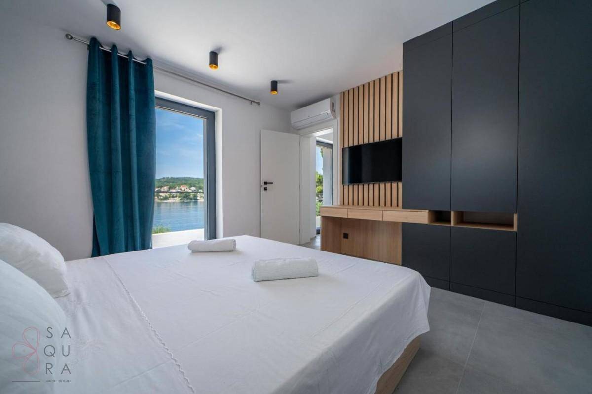 Schlafzimmer mit direktem Zugang zur Terrasse und Blick auf das Meer, ausgestattet mit Klimaanlage.