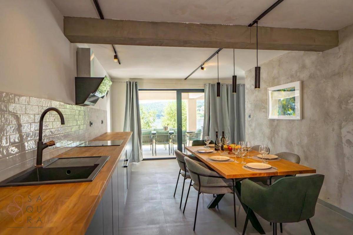 Moderne Küche und Essbereich mit Zugang zur Terrasse, ideal für gesellige Abende mit Meerblick.