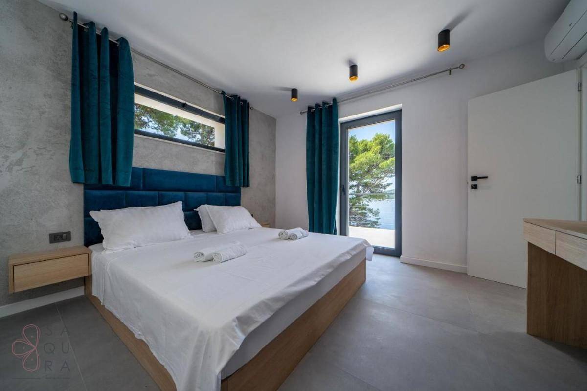 Helles Schlafzimmer mit Doppelbett und großem Fenster, das einen schönen Blick auf die Umgebung bietet.