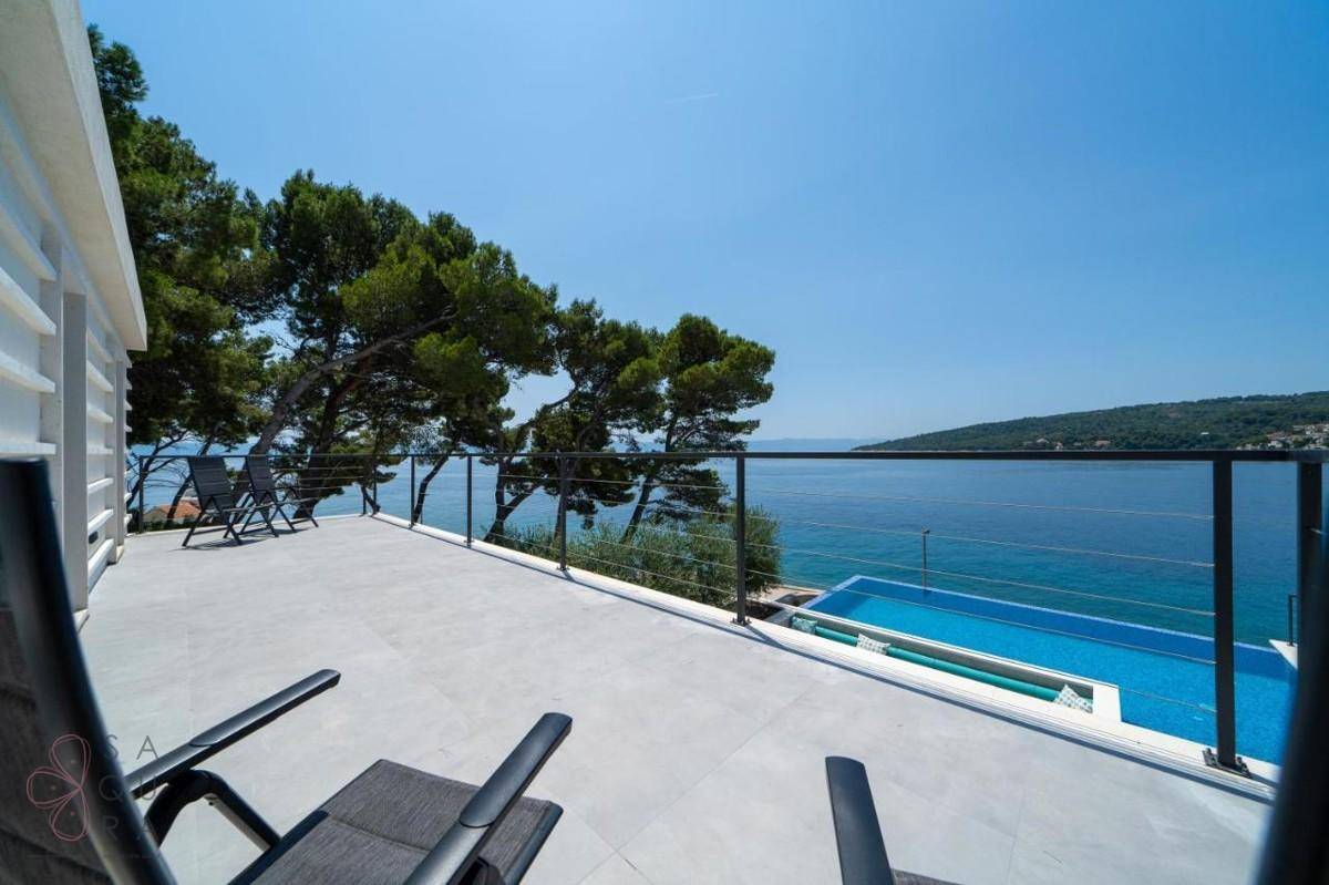 Großer Balkon mit Liegestühlen und atemberaubendem Panoramablick auf das weite Meer.