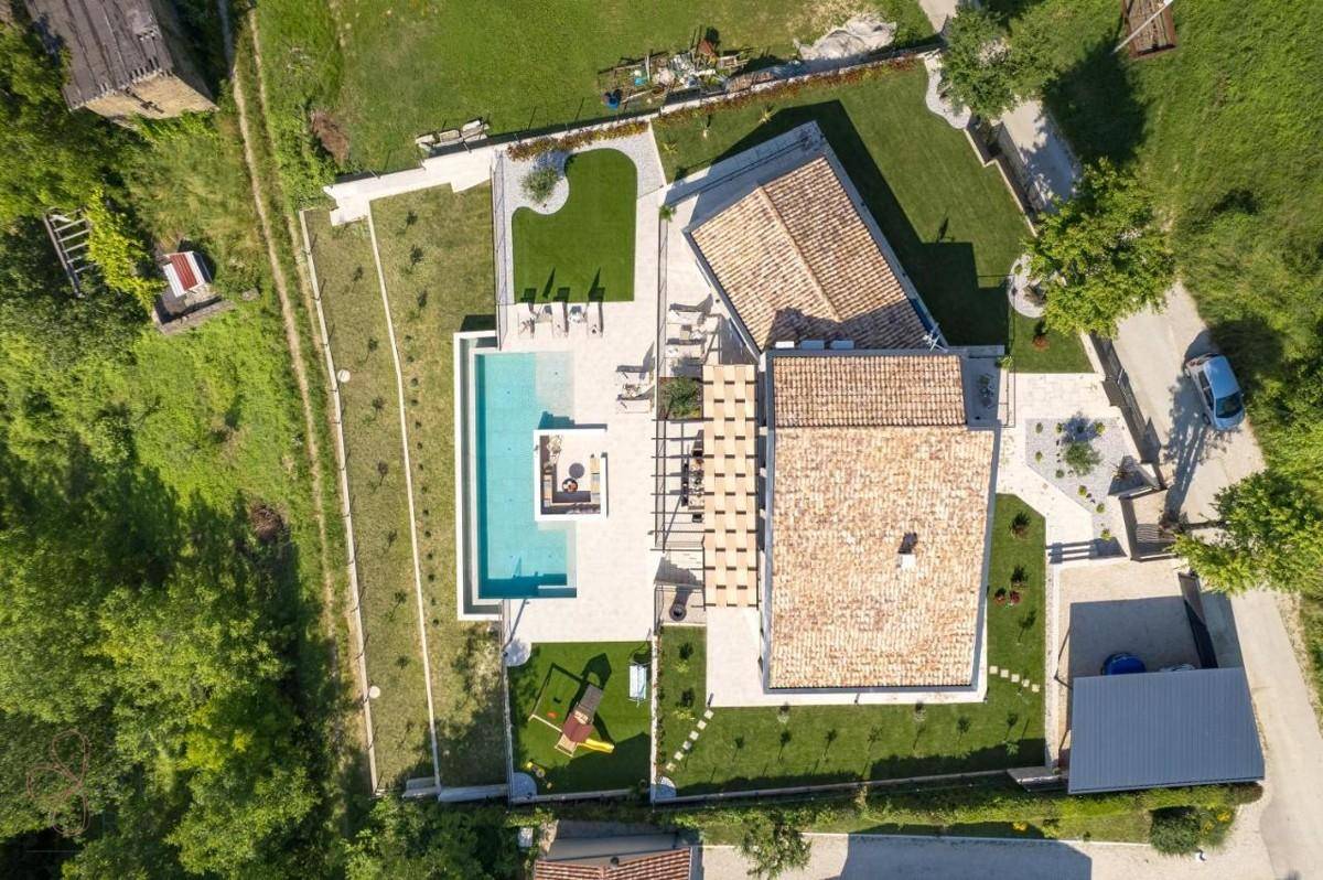Luftaufnahme der gesamten Villenanlage mit Pool, Gärten und umliegender Natur.
