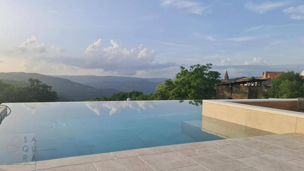 Infinity-Pool mit atemberaubendem Blick auf die umliegende Hügellandschaft und den Horizont.