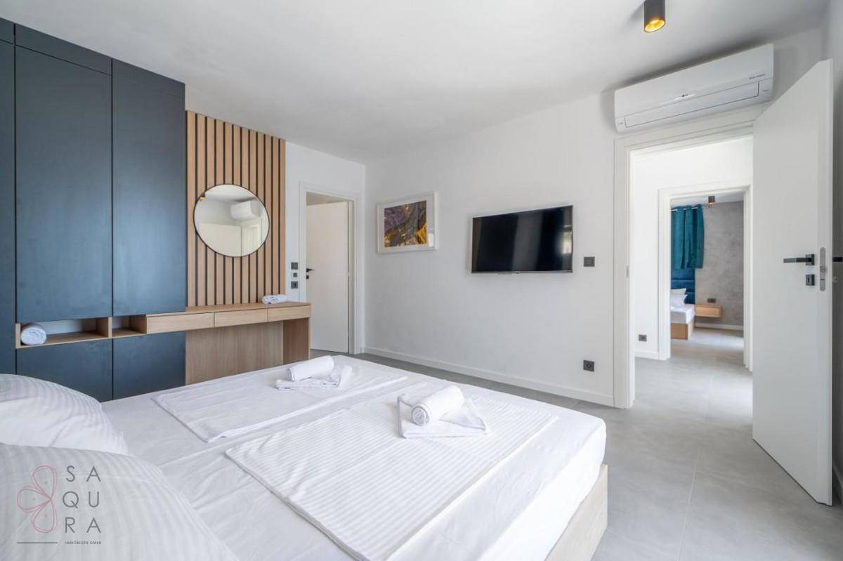 Geräumiges Schlafzimmer mit integrierten Schränken und Zugang zu einem angrenzenden Badezimmer.